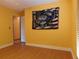 Bedroom featuring light wood flooring, a bright yellow wall, and a doorway to an adjacent room at 130 Krider Rd, Sanford, FL 32773