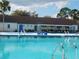 The community pool provides a scenic area to spend hot days, with chairs, tables and a clubhouse in the background at 130 Krider Rd, Sanford, FL 32773