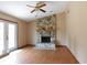 Cozy living room featuring a stone fireplace and wood-look flooring, filled with natural light at 130 Krider Rd, Sanford, FL 32773