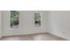 Bright bedroom with wood floors, two windows, and neutral paint at 1371 Lake Dr, Casselberry, FL 32707