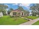 Attractive home showcasing lush green grass, mature trees, and a brick pathway leading to the front door at 1371 Lake Dr, Casselberry, FL 32707