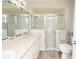 Bright bathroom featuring a glass-enclosed shower, vanity with storage, and modern fixtures at 139 Randle Ave, Oak Hill, FL 32759