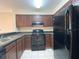 Functional kitchen features dark appliances, brown cabinets, and neutral countertops, ready for immediate use at 14025 Fairway Island Dr # 335, Orlando, FL 32837