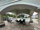 View of an outdoor lounge and pool area with table seating, pillars, and tile floors at 14025 Fairway Island Dr # 335, Orlando, FL 32837