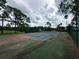 Tennis court with surrounding trees, landscaping, and distant views of the wider green area at 14025 Fairway Island Dr # 335, Orlando, FL 32837