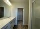 Bright bathroom features a single sink vanity, wood-look flooring, and a walk-in closet at 1407 Mount Royal Dr, St Cloud, FL 34771