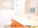 Bright bathroom featuring a wood vanity, decorative mirror, and glass block accent at 1430 Arrowhead Trl, Deltona, FL 32725