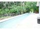 Long in-ground pool with a spacious deck and a safety fence for added security at 1430 Arrowhead Trl, Deltona, FL 32725