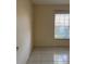 Bedroom with tiled flooring and a window with blinds, providing a simple and functional space at 14844 Laguna Beach Cir, Orlando, FL 32824