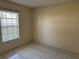 Bedroom with tiled flooring and a window with blinds, offering a neutral and adaptable space for relaxation at 14844 Laguna Beach Cir, Orlando, FL 32824