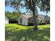 Landscaped front yard with mature trees and a well-maintained lawn at 14844 Laguna Beach Cir, Orlando, FL 32824