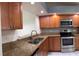 Well-lit kitchen boasts granite countertops, stainless appliances, and wood cabinetry at 14844 Laguna Beach Cir, Orlando, FL 32824