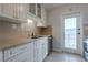 Well-organized kitchen with white cabinetry, tiled backsplash, and a convenient door to the outside at 151 N Orlando Ave # 204, Winter Park, FL 32789