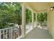 Balcony featuring columns and a white railing with a lush treetop view, offering a private outdoor space at 1630 Common Way Rd # 203, Orlando, FL 32814