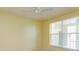 A bright bedroom with a ceiling fan, natural light, and neutral color scheme at 1630 Common Way Rd # 203, Orlando, FL 32814