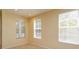 Bright bedroom featuring multiple windows with blinds, neutral walls, and tile floors providing an airy and adaptable living space at 1630 Common Way Rd # 203, Orlando, FL 32814