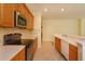 Well-equipped kitchen with stainless steel appliances, wood cabinets, ample countertop space, and tile backsplash, optimizing culinary experience at 1630 Common Way Rd # 203, Orlando, FL 32814