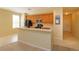 Open kitchen with a breakfast bar, wood cabinets, black appliances, and tile flooring, perfect for entertaining and cooking at 1630 Common Way Rd # 203, Orlando, FL 32814