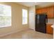 Functional kitchen with ample windows, black refrigerator, wood cabinets, and tile flooring, providing an airy cooking environment at 1630 Common Way Rd # 203, Orlando, FL 32814