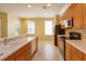 Bright kitchen featuring stainless steel appliances, wood cabinets, an island with sink, and tile flooring, enhancing functionality and style at 1630 Common Way Rd # 203, Orlando, FL 32814