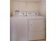 A clean laundry room area with white washer and dryer appliances that offer convenience for laundry needs at 1630 Common Way Rd # 203, Orlando, FL 32814