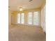 Bright living room featuring glass doors to balcony, neutral walls, ceiling fan and carpet, providing abundant natural light at 1630 Common Way Rd # 203, Orlando, FL 32814