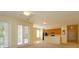 Bright living room featuring a ceiling fan, access to a balcony, and an open-concept kitchen at 1630 Common Way Rd # 203, Orlando, FL 32814