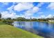 Scenic view of the pond and lush greenery, under a blue sky dotted with fluffy white clouds at 1630 Common Way Rd # 203, Orlando, FL 32814