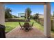 Cozy backyard patio area with table, chairs, grill, and manicured lawn at 17199 Hickory Wind Dr, Clermont, FL 34711