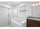 Bright bathroom featuring a glass-enclosed shower and tub combo with granite vanity and ample natural light at 17199 Hickory Wind Dr, Clermont, FL 34711