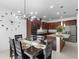 Dining room with stylish chandelier, adjacent to a modern kitchen with stainless appliances and granite counters at 17199 Hickory Wind Dr, Clermont, FL 34711
