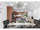 Open-concept dining room with stylish chandelier adjacent to a modern kitchen with granite countertops at 17199 Hickory Wind Dr, Clermont, FL 34711