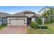 Charming single-story home featuring a brick driveway and well-manicured landscaping at 17199 Hickory Wind Dr, Clermont, FL 34711