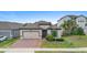 Inviting single-story home with a brick driveway and lush green lawn at 17199 Hickory Wind Dr, Clermont, FL 34711