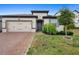 Charming single-story home with a brick driveway and well-manicured landscaping at 17199 Hickory Wind Dr, Clermont, FL 34711