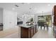 Open kitchen with island, granite countertops, and a breakfast bar flows into the dining and living areas at 17199 Hickory Wind Dr, Clermont, FL 34711