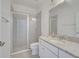 Bright bathroom featuring granite countertop vanity, white cabinets, and a glass-enclosed shower at 17333 Hickory Wind Dr, Clermont, FL 34711