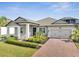Charming single-story home showcasing a brick driveway, well-maintained landscaping, and a welcoming entrance at 17333 Hickory Wind Dr, Clermont, FL 34711