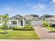 Charming single-story home showcasing a brick driveway, well-maintained landscaping, and a welcoming entrance at 17333 Hickory Wind Dr, Clermont, FL 34711