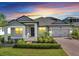 Charming single-story home showcasing a brick driveway, well-maintained landscaping, and a welcoming entrance at 17333 Hickory Wind Dr, Clermont, FL 34711
