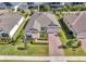 Beautiful single-Gathering home with a well-manicured lawn, paver driveway, and lush landscaping at 17333 Hickory Wind Dr, Clermont, FL 34711