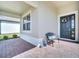 Cozy front porch featuring a decorative wreath, bench with pillows, and stylish blue and white ceramic vases at 17333 Hickory Wind Dr, Clermont, FL 34711