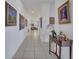 Hallway with decorative artwork leading to the living area with a sofa and an area rug at 17333 Hickory Wind Dr, Clermont, FL 34711
