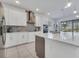 Modern kitchen featuring stainless steel appliances, white cabinetry, and a large island with gray accents at 17333 Hickory Wind Dr, Clermont, FL 34711