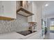 Modern kitchen boasts white cabinetry, stainless steel appliances, quartz countertops, and unique mosaic backsplash at 17333 Hickory Wind Dr, Clermont, FL 34711