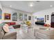 Bright living room with modern decor, large windows, tiled floors, and comfortable seating at 17333 Hickory Wind Dr, Clermont, FL 34711