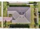 Aerial view of a brown shingle roof with skylights, surrounded by green landscaping and a brick driveway at 17333 Hickory Wind Dr, Clermont, FL 34711