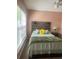 Comfortable bedroom featuring a wood headboard, soft bedding, and plenty of natural light at 17517 Silver Creek Ct, Clermont, FL 34714