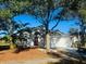 Charming single-story home with a well-maintained front yard and mature trees, featuring a red front door and attached garage at 17517 Silver Creek Ct, Clermont, FL 34714