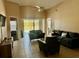 Cozy living room with tile floors, ceiling fan, and sliding glass doors offering a view of the pool and backyard at 17517 Silver Creek Ct, Clermont, FL 34714